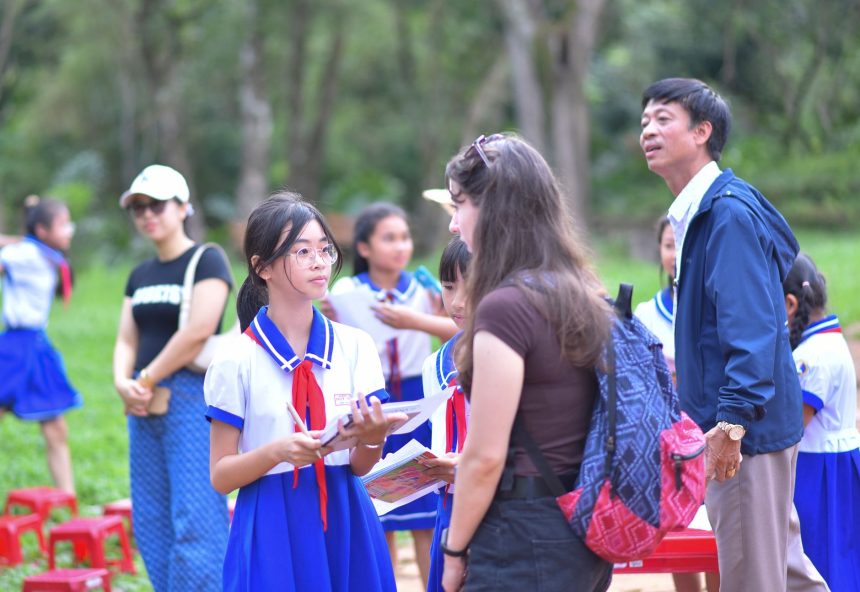 Grupo de estudantes uniformizados participa de uma atividade educativa ao ar livre com professores.