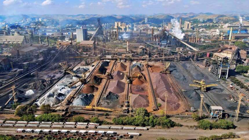 Vista ampla de uma instalação industrial de mineração, com máquinas e pilhas de rejeitos.