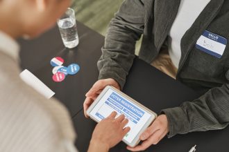 Pessoa usando um tablet em uma estação de atendimento eleitoral.