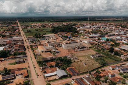 Vista aérea de uma área urbana de Oiapoque, com ruas, casas e vegetação sob céu nublado.