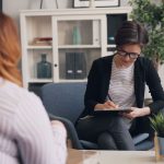 Duas mulheres conversam durante uma sessão de apoio em ambiente reservado.